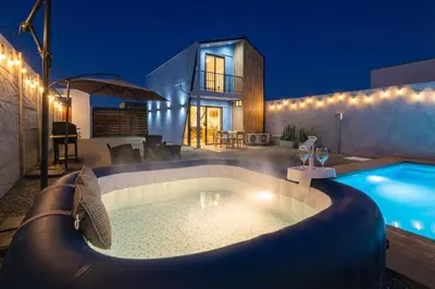 a house with a swimming pool at night at Tiny House con Piscina Privada, Jacuzzi, Parrilla y Starlink in Punta Negra
