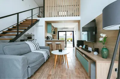 a living room with a couch and a staircase at Tiny House con Piscina Privada, Jacuzzi, Parrilla y Starlink in Punta Negra