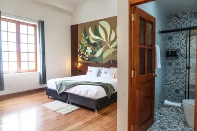 a bedroom with a bed and a painting on the wall at Bosco Hotel Boutique in Cusco