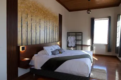 a bedroom with a bed with a painting on the wall at Bosco Hotel Boutique in Cusco