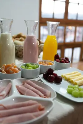 a table topped with plates of food and bottles of milk at Bosco Hotel Boutique in Cusco