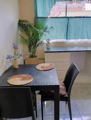 a black table with two chairs and a kitchen at centrico departamento in Cusco