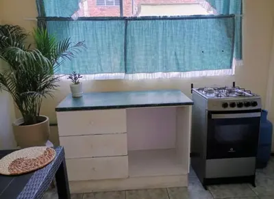 a small kitchen with a stove and a window at centrico departamento in Cusco