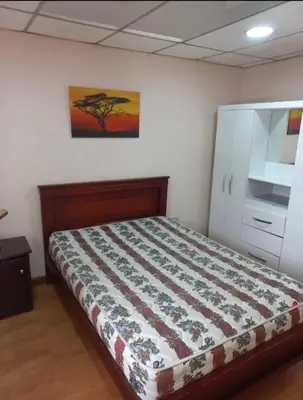 a bedroom with a bed and a painting on the wall at centrico departamento in Cusco