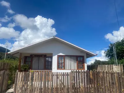 a small white house with a wooden fence at Mi lagartitas Bungalow in Oxapampa