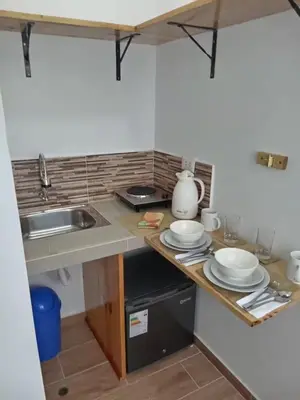 a small kitchen with a sink and a counter top at Mi lagartitas Bungalow in Oxapampa