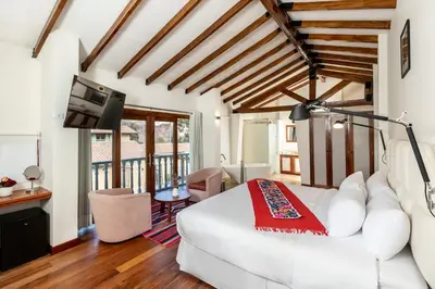 a living room with a white couch and a tv at Casa Eva Hotel Boutique in Urubamba