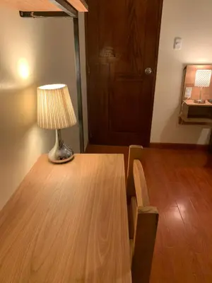 a lamp sitting on a wooden table in a room at Juliet's House in Ollantaytambo