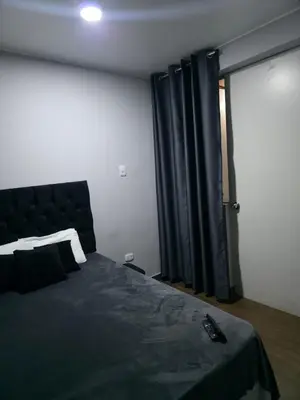 a bedroom with a bed and a sliding glass door at Aero- apartamento in Lima