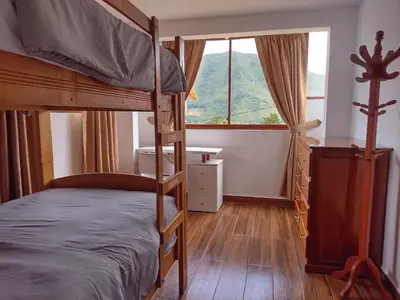 a bedroom with a bunk bed and a window at Sweet Home Oxapampa in Oxapampa