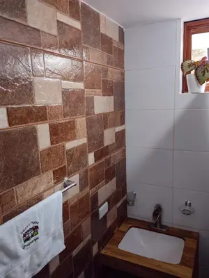 a bathroom with a sink and a tile wall at Sweet Home Oxapampa in Oxapampa