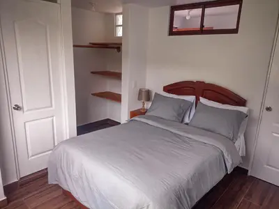 a bedroom with a large bed with blue pillows at Sweet Home Oxapampa in Oxapampa