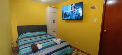 a bedroom with a bed with a tv on the wall at Habitación H4, TV y WIFI cerca a Barranco in Lima