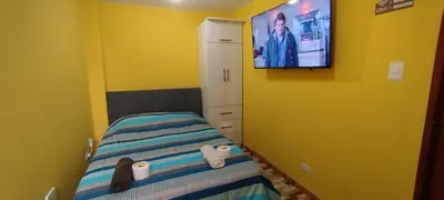a bedroom with a bed with a tv on the wall at Habitación H4, TV y WIFI cerca a Barranco in Lima