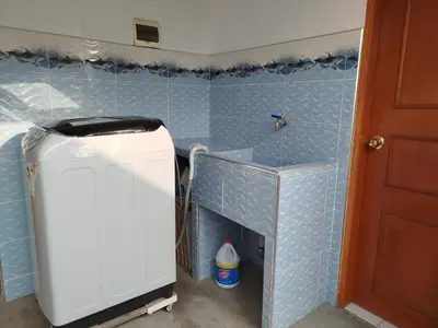a small refrigerator in a kitchen with blue tiles at Habitación H4, TV y WIFI cerca a Barranco in Lima