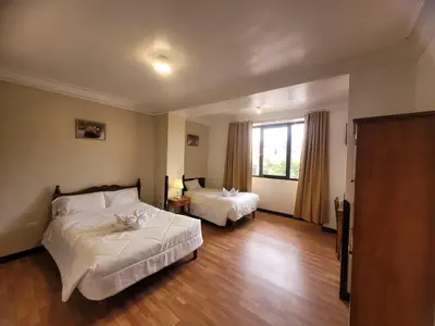 a hotel room with two beds and a window at HOTEL HUAYNAPATA Pardo in Cusco