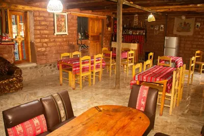 a restaurant with tables and chairs in a room at Hospedaje Pumayalli in Urubamba