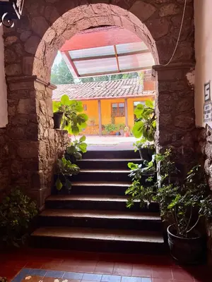an archway with stairs leading to a building at Inka Tambo Hacienda in Cusco