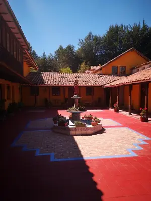 a courtyard with a fountain in the middle of a building at Inka Tambo Hacienda in Cusco