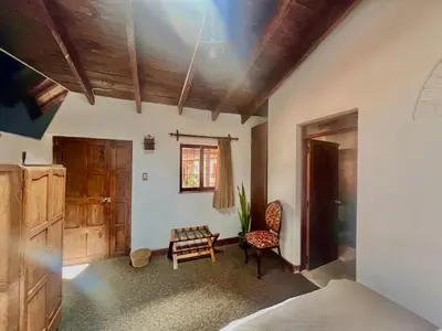 a bedroom with a bed and a chair and a window at Inka Tambo Hacienda in Cusco