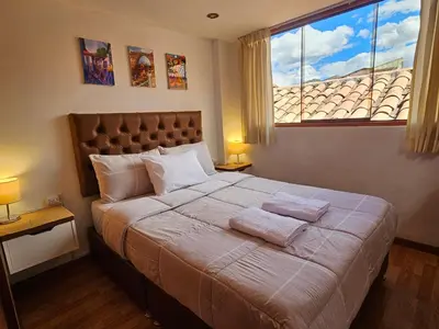 a bedroom with a large bed with two towels on it at SAMAY WASI b&b in Cusco
