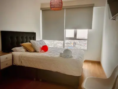 a bedroom with a bed with a large window at departamento nuevo con espectacular vista entre surco y Miraflores in Lima