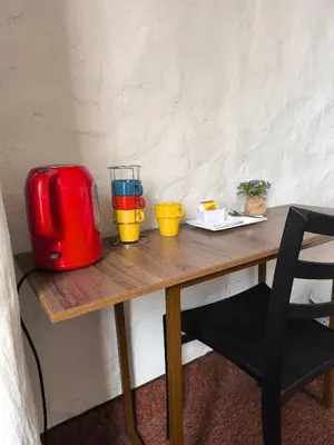 a table with a toaster and some cups on it at Waalay Hotel in Huancayo