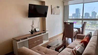 a living room with a couch and a flat screen tv at Apartment in front of the Ricardo Palma Clinic in Lima