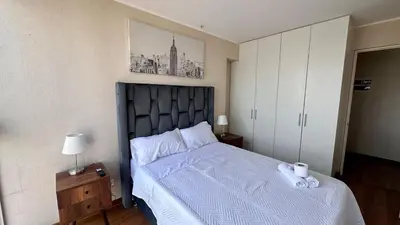 a bedroom with a large bed with a blue comforter at Apartment in front of the Ricardo Palma Clinic in Lima