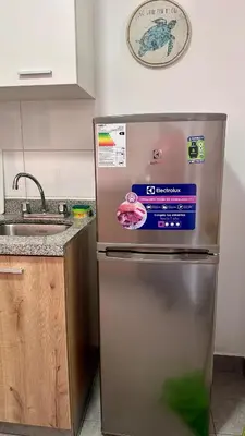 a kitchen with a stainless steel refrigerator and a sink at Apartment in front of the Ricardo Palma Clinic in Lima