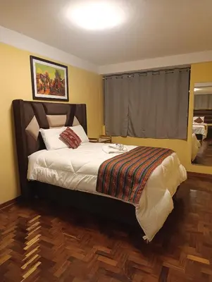 a bedroom with a large bed with a wooden floor at The Culinary Stay and Taste in Cusco
