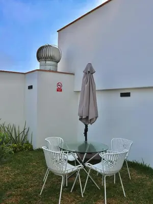 a table with three chairs and an umbrella at Craviz house ,a home away from home in Lima