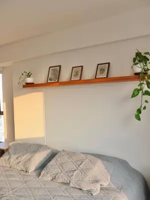 a bedroom with a bed and a shelf on the wall at Craviz house ,a home away from home in Lima