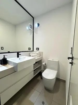 a bathroom with a toilet and a sink and a mirror at San Isidro 1 Bedroom RN in Lima