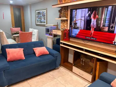 a living room with a blue couch and a tv at Departamento Palmeras in Lima