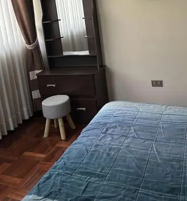 a bedroom with a bed and a chair and a dresser at Departamento centrico cusco in Cusco