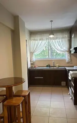 a kitchen with a sink and a table and a window at Departamento centrico cusco in Cusco