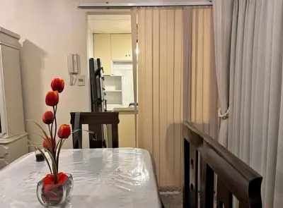 a table with a vase with red flowers on it at Apartment in cusco center in Cusco