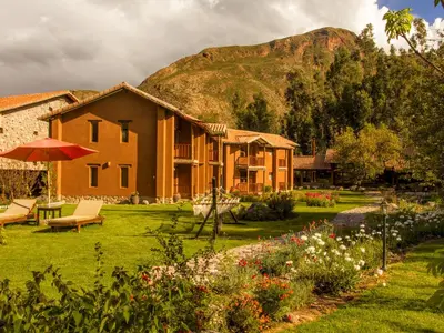 a house with a garden and a mountain in the background at Lizzy Wasi Urubamba in Urubamba