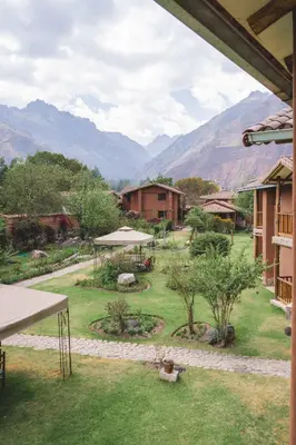 a view of a garden with mountains in the background at Lizzy Wasi Urubamba in Urubamba