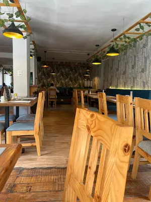 a dining room with wooden chairs and tables and tablesearcher at Hotel Litan Machu Picchu in Machu Picchu