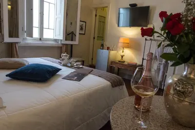a bedroom with a bed with a vase of roses and a wine glass at Casa Falleri Boutique Hotel in Lima