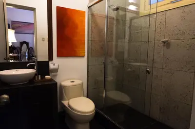 a bathroom with a toilet and a glass shower at Casa Falleri Boutique Hotel in Lima