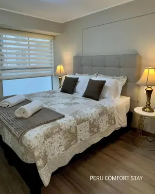 a bedroom with a large bed with pillows and a window at Luxurious brand new apartment in Lima