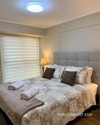 a bedroom with a large bed with pillows on it at Luxurious brand new apartment in Lima