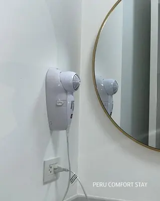 a mirror on a wall with a hair dryer at Luxurious brand new apartment in Lima