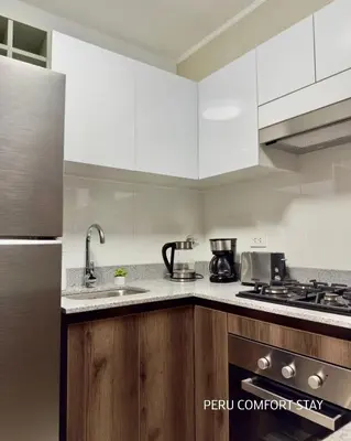 a kitchen with white cabinets and a sink at Luxurious brand new apartment in Lima
