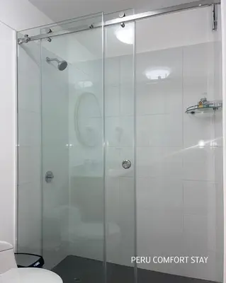 a shower with a glass door in a bathroom at Luxurious brand new apartment in Lima