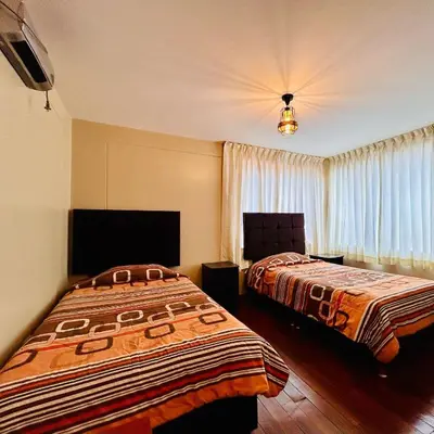a hotel room with two beds and a window at Hotel la Casa de Makito's in Cusco