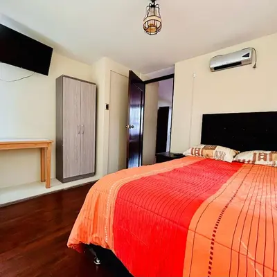 a bedroom with a large bed with a red blanket at Hotel la Casa de Makito's in Cusco